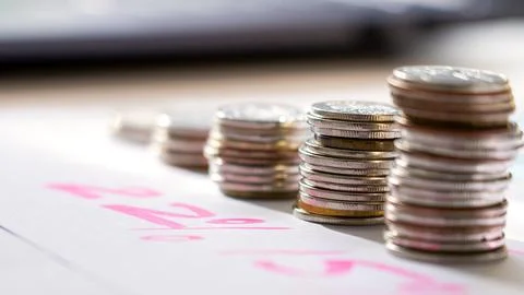 A stack of coins with a pink line on a white background Stock Photos