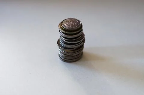 Stack of coins on a plain surface, symbolizing financial savings or economy Stock Photos
