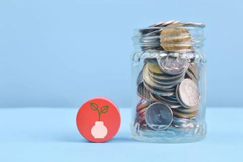 Stack of coins with plant symbol. Saving concept Stock Photos