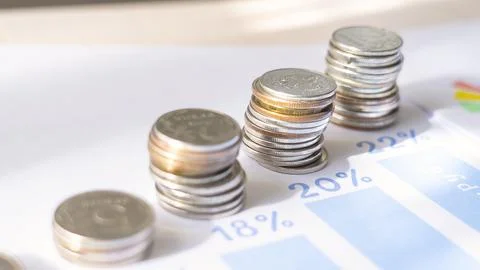 A stack of coins on a table with a blue background Stock-Fotos