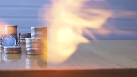 A stack of coins on the table lit by the flame of a gas burner Stock Footage 212384966