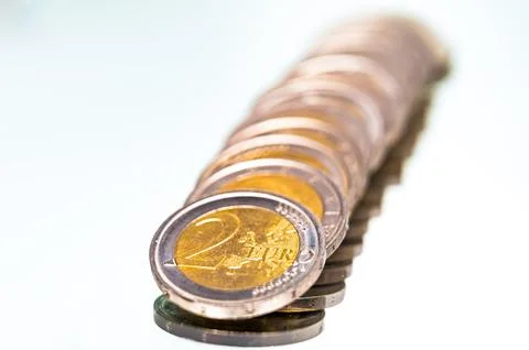 Stack of coins on white surface. Stock Photos