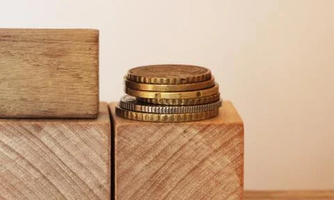 Stack of coins on wooden cubes with copyspace. Financial concept Stock Photos