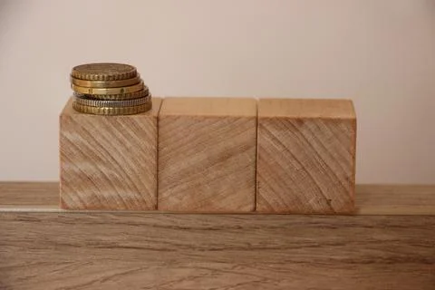 Stack of coins on wooden cubes with copyspace. Financial concept 库存照片