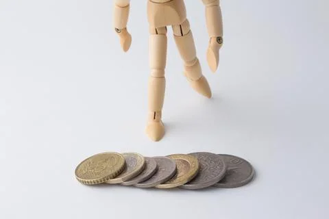 Stack of coins with wooden dummy Stock Photos