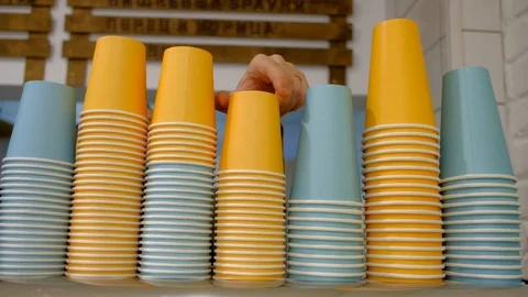 Stack of color disposable coffee cup. Mans hand takes colored paper cups. Stock Footage 100099041