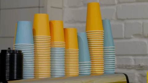 Stack of color disposable coffee cup. Man's hand takes colored paper cups. Stock Footage 100099171