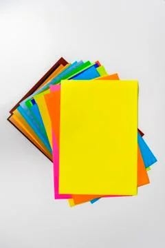 A stack of of color paper sheets on the table flat lay, view from above Stock Photos