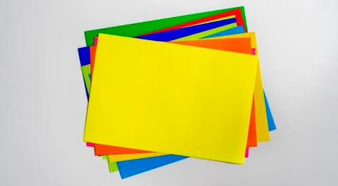 A stack of of color paper sheets on the table flat lay, view from above Foto stock