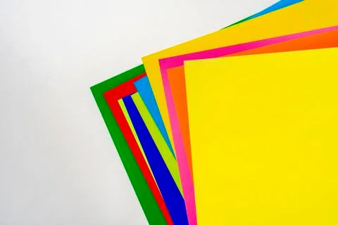 A stack of of color paper sheets on the table flat lay, view from above Stock Photos
