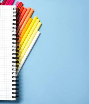 Stack of color pencil and notebook on blue paper background. Business object. Stock-Fotos