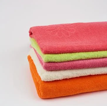 Stack of colored cotton terry folded towels on a white background Stock-Fotos