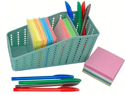 Stack of colored paper, colored pens and basket for pens Stock Photos