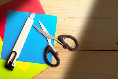 Stack of colored paper with scissors and cutter Stock Photos