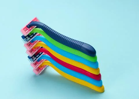 Stack of colored plastic razors on blue background 库存照片