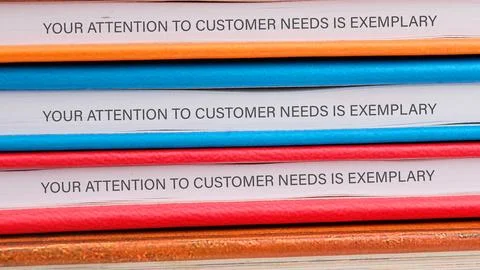 A stack of colorful binders displays the phrase, demonstrating a commitment t 스톡 사진