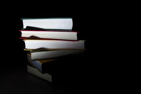 Stack of colorful books on a black background Stock Photos