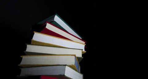 Stack of colorful books on a black background Stock Photos