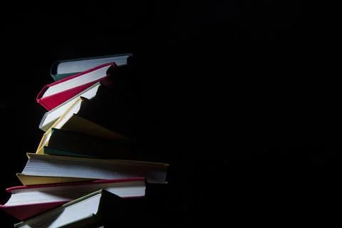Stack of colorful books on a black background Foto stock