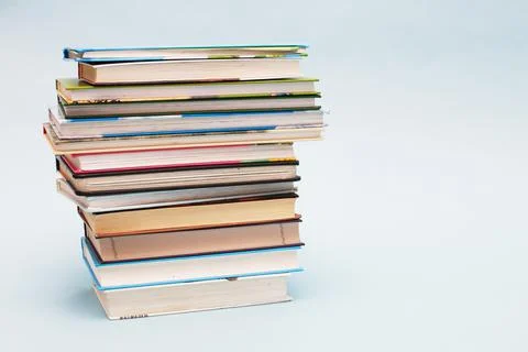 Stack of colorful books on blue background with copy space. Back to school co Fotos Stock