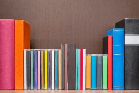 Stack of colorful books, cd and cassettes in the book self Stock Photos
