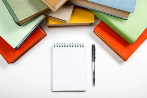 Stack of colorful books, notebook with blank sheet paper and pen on wooden table Stock Photos
