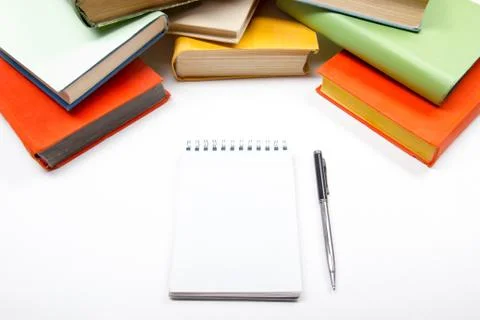 Stack of colorful books, notebook with blank sheet paper and pen on wooden table Stock Photos