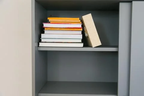 Stack of colorful books on shelf. Knowledge, curiosity, and personal growth w Stock Photos