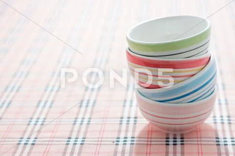 Stack of colorful bowls on fabric background Stock Photos