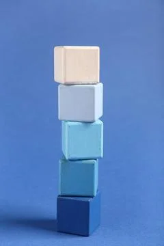 Stack of colorful building cubes on blue background Stock Photos