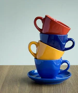 Stack of colorful coffee cups on table Stock Photos