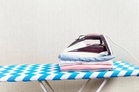 Stack of colorful cotton clothes and iron.Household laundry ironing. Foto stock