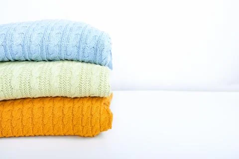 Stack of colorful cozy comfortable homely clean washed knitted sweaters in Stock Photos