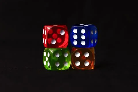 Stack of colorful dice against a black background Stock Photos