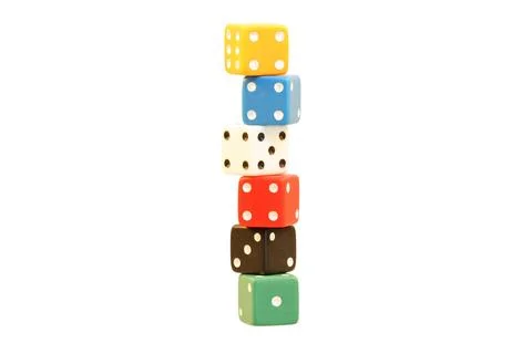 Stack of colorful dice balanced on top of each other against a white background Stock Photos