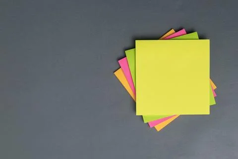 Stack of colorful empty sticky notes with copy space on gray background Stock Photos