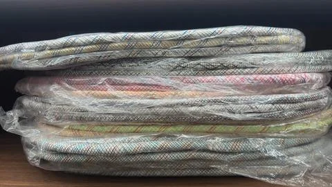 Stack of colorful fabric wrapped in transparent plastic, ready for use. Stock-Fotos