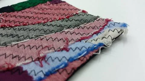 Stack of colorful fabrics with decorative stitching. 库存照片