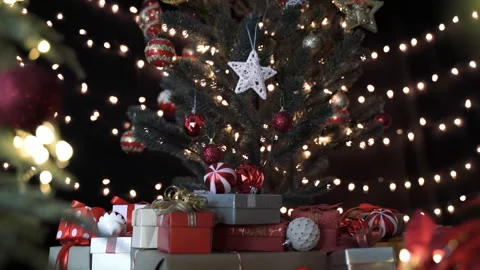 Stack of colorful gift boxes under christmas tree and decoration in living room Stock Footage 140976434