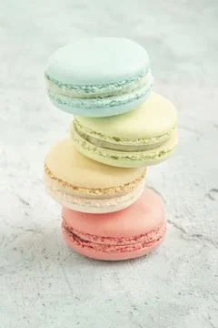 Stack of colorful macaroons on green background with copy space Stock Photos