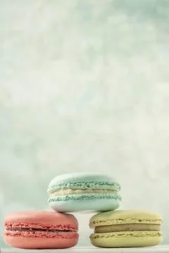 Stack of colorful macaroons over green with copy space Stock Photos