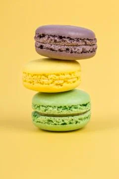 Stack of colorful macaroons on yellow background Stock Photos