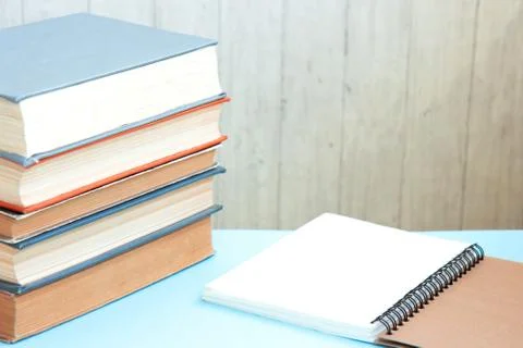 Stack of colorful old hardback books with brown notebook. Many Books Piles Stock Photos