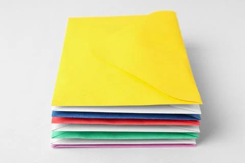 Stack of colorful paper envelopes on light background Foto stock