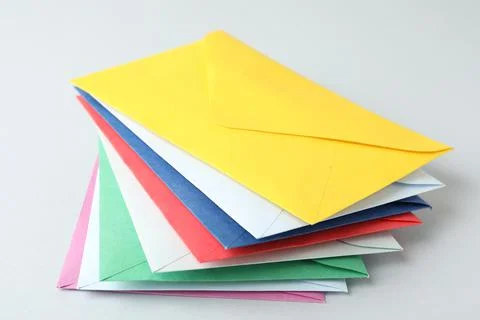Stack of colorful paper envelopes on light background Foto stock