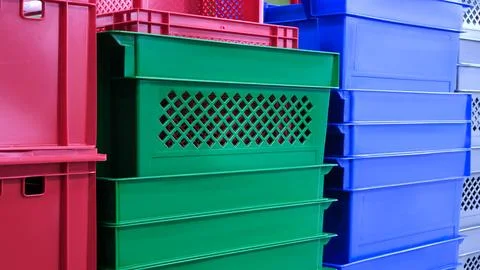 A stack of colorful plastic containers, including green, red, and blue. The c Foto stock
