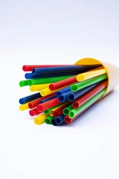 Stack of colorful plastic straws in a cup with white background Stock Photos