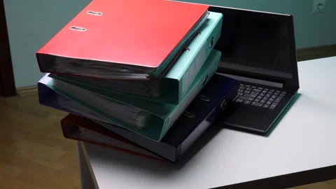 Stack of colorful ring binders filled with documentation and paperwork next to Stock Footage 345170005