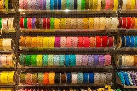 Stack of colorful sewing threads, spools of thread on shelves at retail store Stock Photos