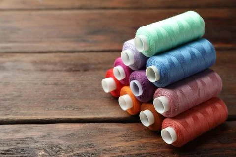 Stack of colorful sewing threads on wooden table. Space for text 스톡 사진